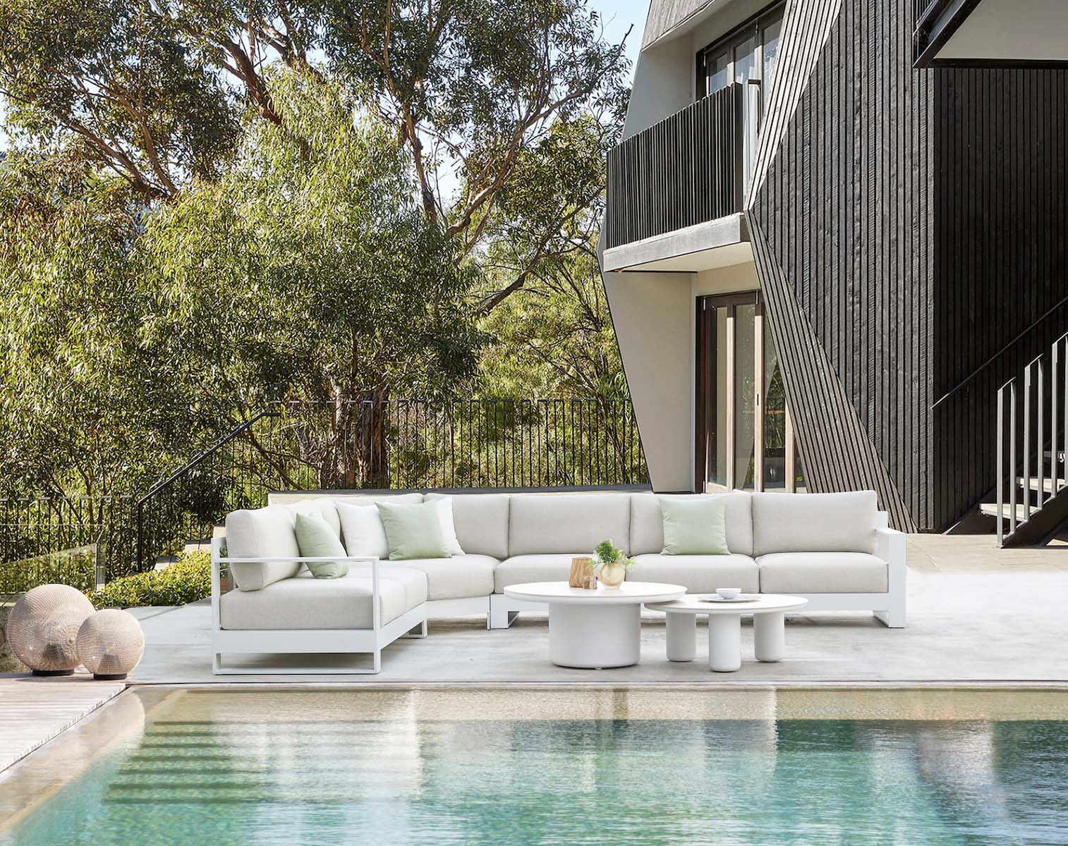 Salon d'angle modulable en aluminium haut de gamme blanc avec coussins en tissu oléfine Sunproof beige, table basse ronde.