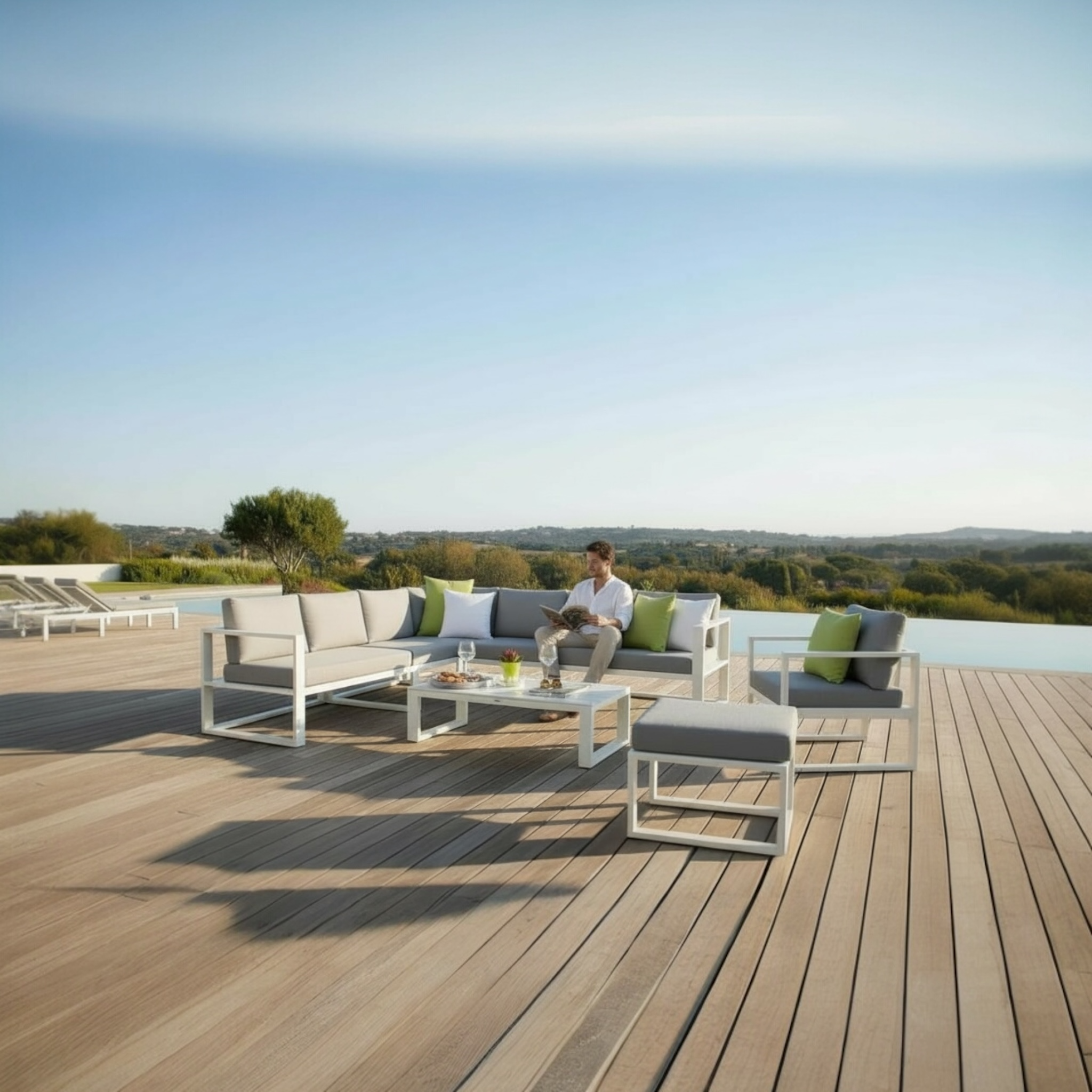 Salon de jardin extérieur luxe modulable en aluminium haut de gamme, poufs et canapé beige aux coussins gris et verts.