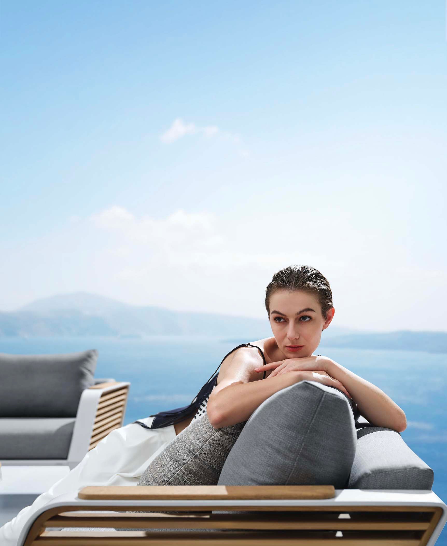 Salon de jardin luxueux 7 places en aluminium et Teck FSC, design Pininfarina, coussins gris haut de gamme, lignes épurées.