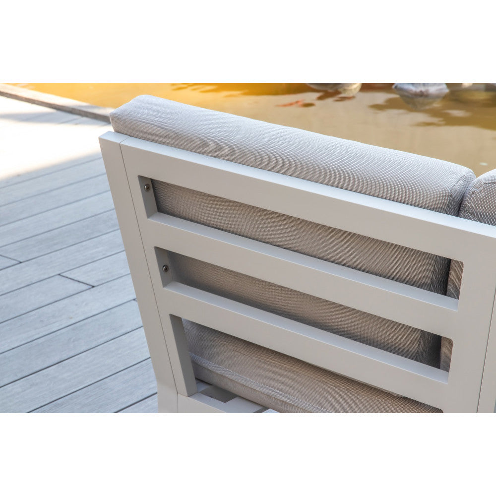 Détail d’accoudoir en aluminium haut de gamme blanc mat, coussins en tissu oléfine beige, structure luxe avec teck FSC.