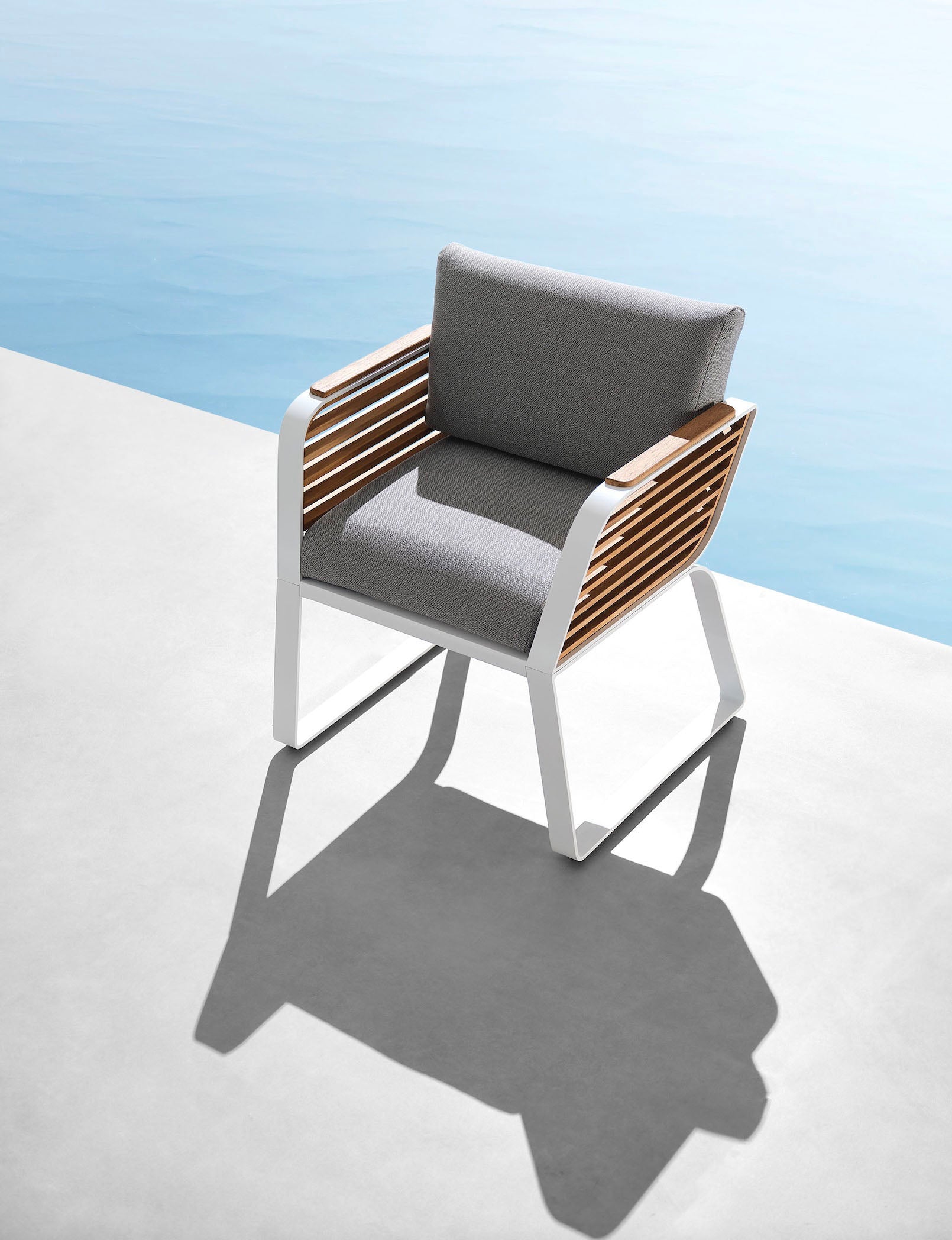 Fauteuil jardin luxueux design Pininfarina en aluminium blanc et Teck FSC durable, coussins gris haut de gamme au style.