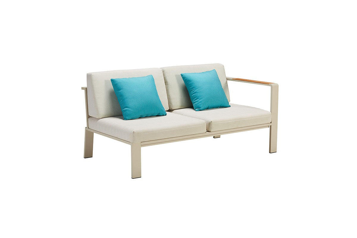Salon de jardin d'angle luxe en aluminium haut de gamme beige avec assise en tissu oléfine gris clair, coussins bleus.