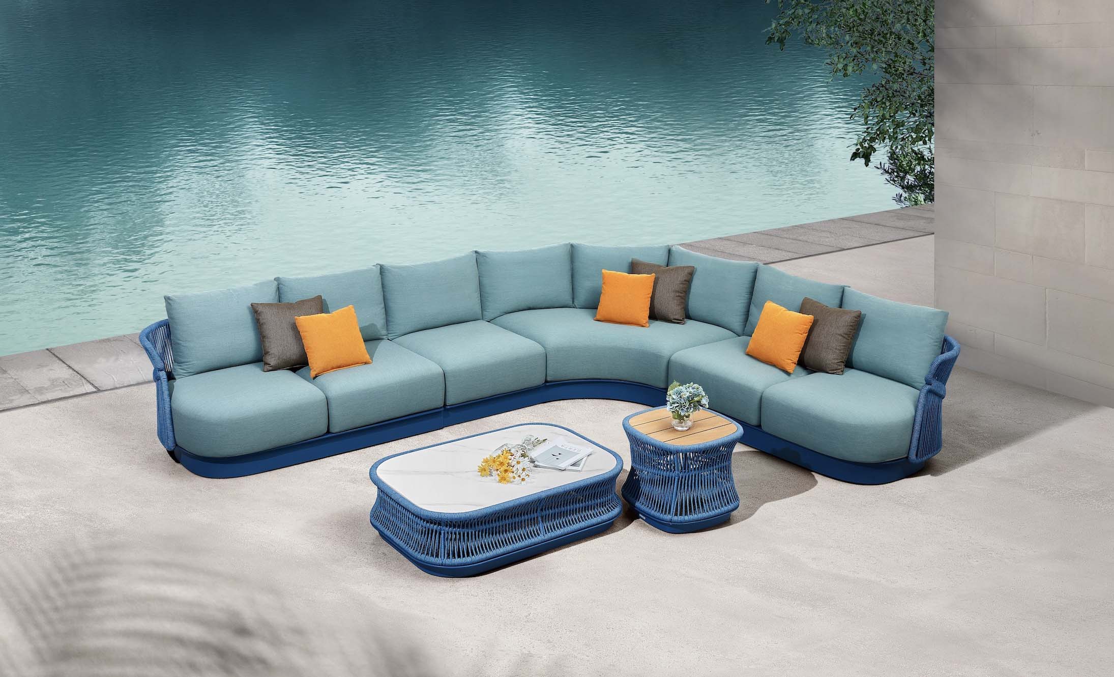 Salon d’angle design italien luxueux en aluminium et corde tressée bleue, coussins bleus et oranges, table basse et ottoman.