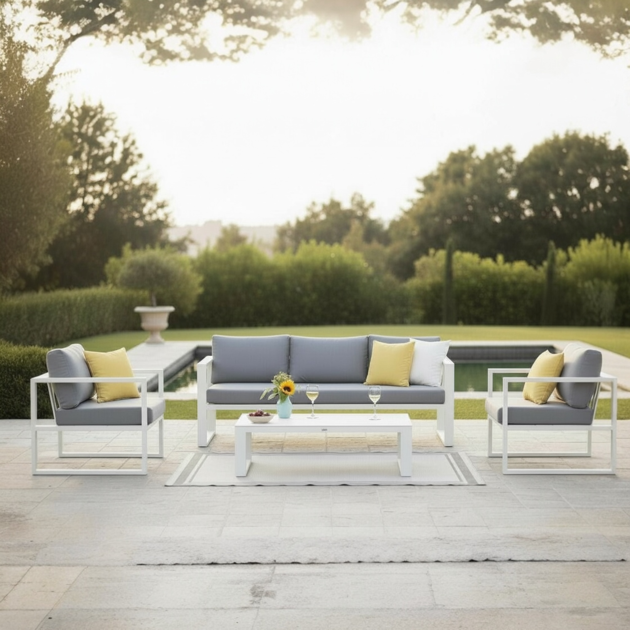Salon de jardin modulable en aluminium blanc haut de gamme, canapés et fauteuils avec coussins gris et petits coussins.