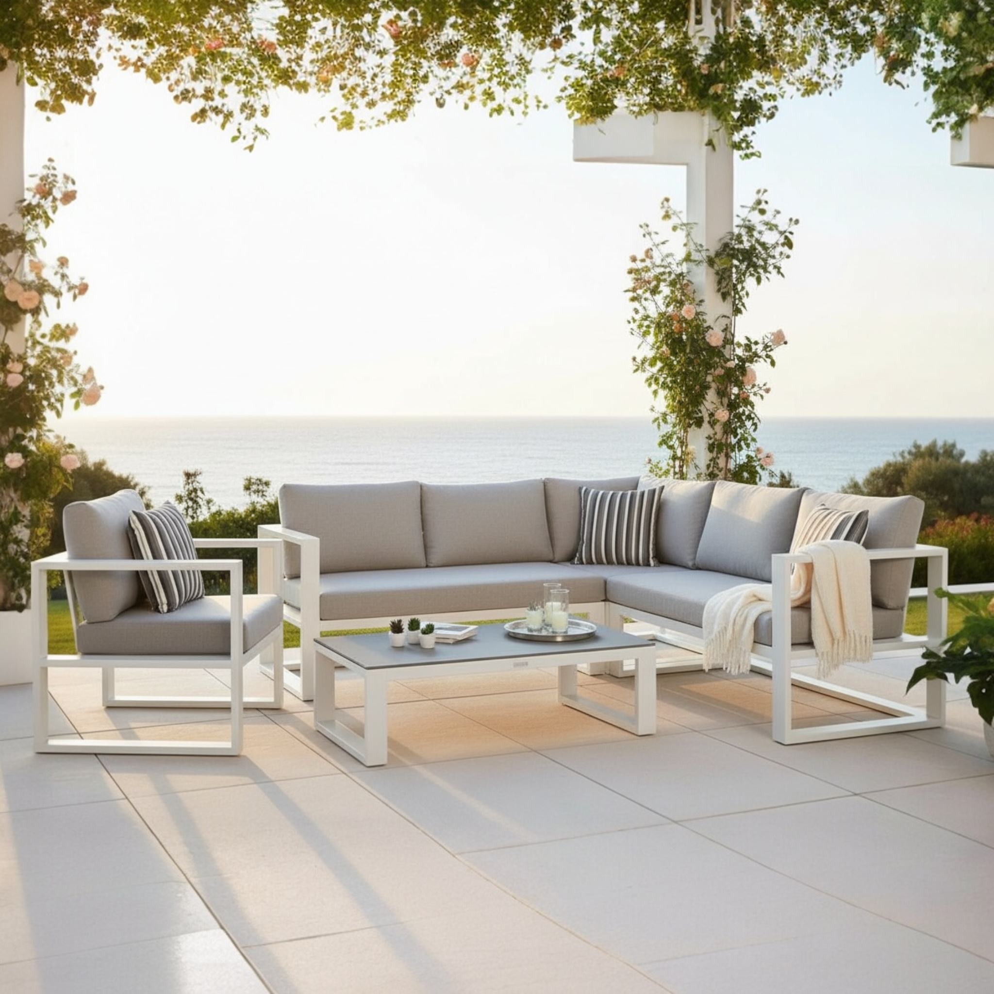 Salon de jardin d'angle modulable en aluminium blanc, design haut de gamme, coussins gris clair, ambiance élégante.