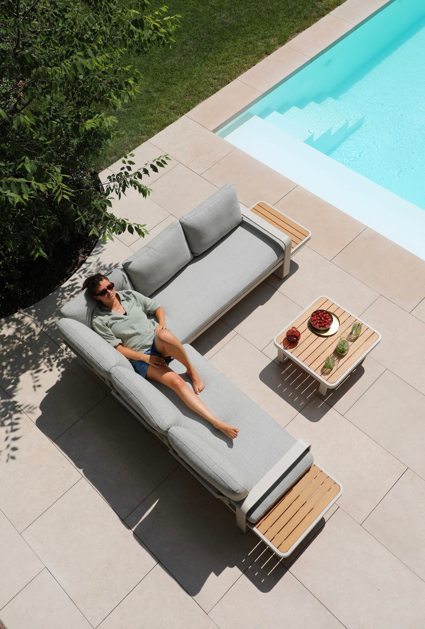 Salon de jardin d'angle modulable en aluminium inoxydable et teck FSC, coussins déhoussables et déperlants gris clair.