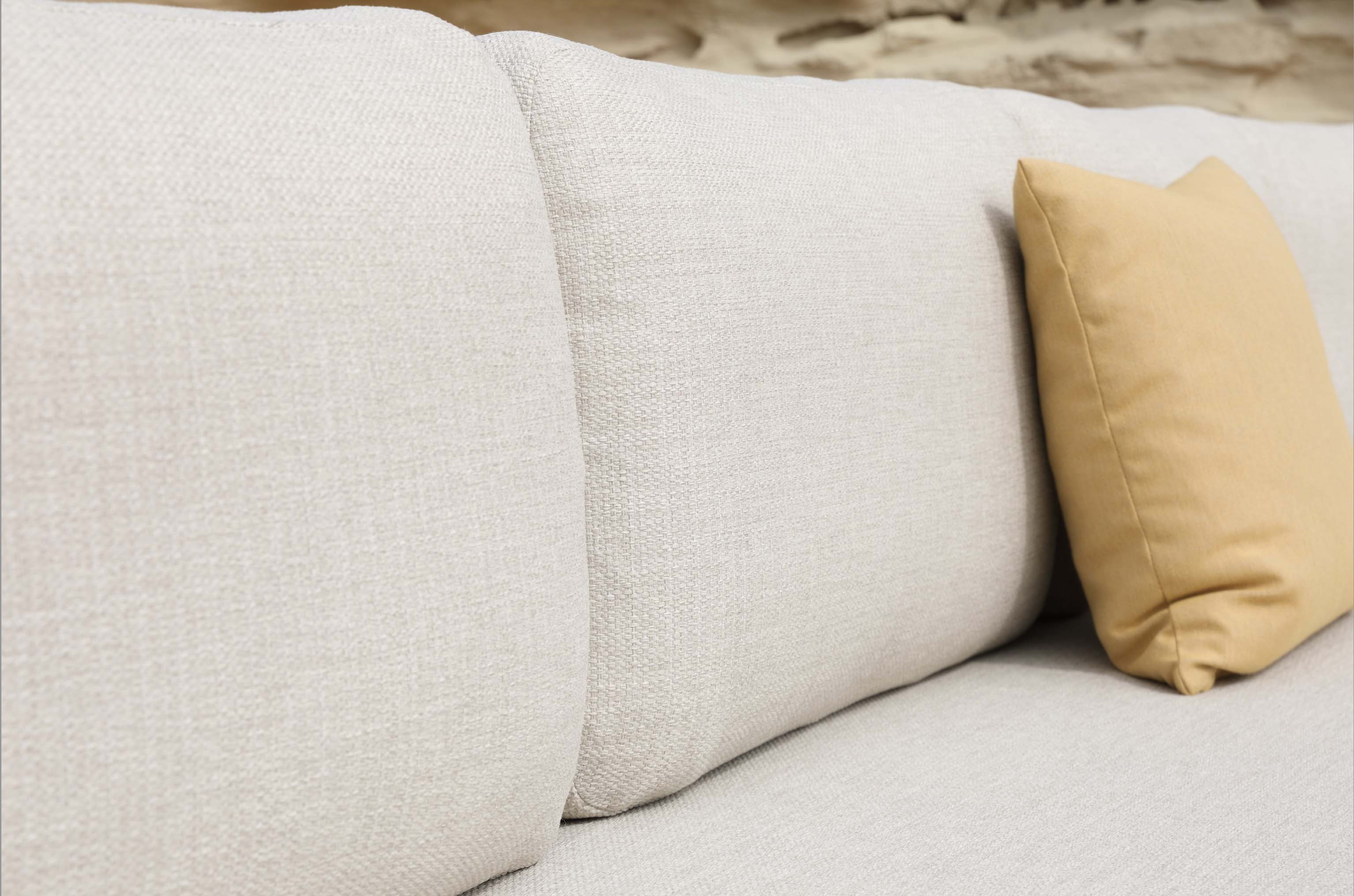 Coussin beige clair en textile haut de gamme sur salon d'angle en aluminium avec finition peinture époxy, détail d’oreiller.