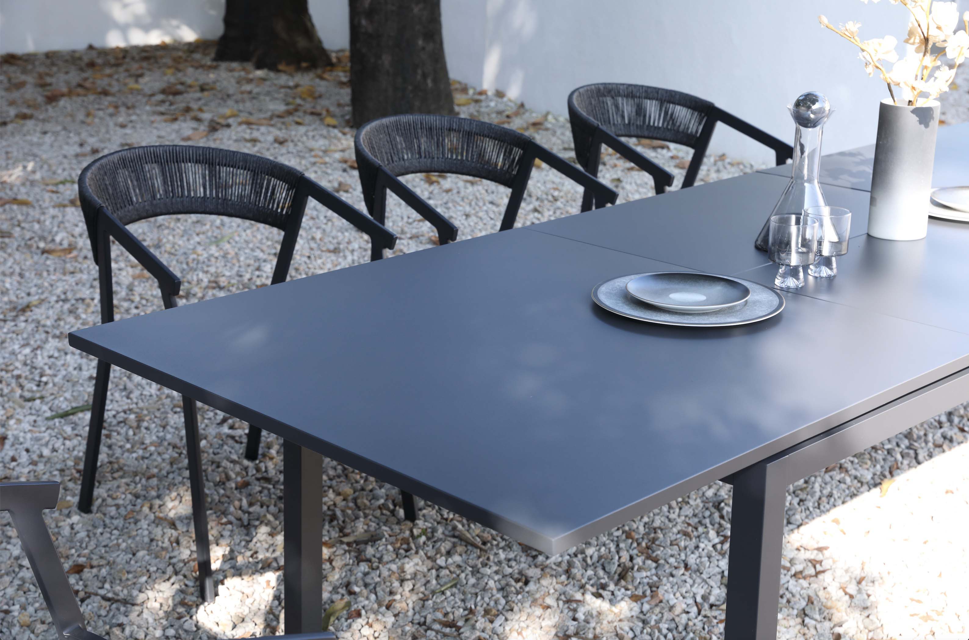 Table extensible en aluminium haut de gamme inoxydable noir avec plateau lisse et pieds solides, design élégant.