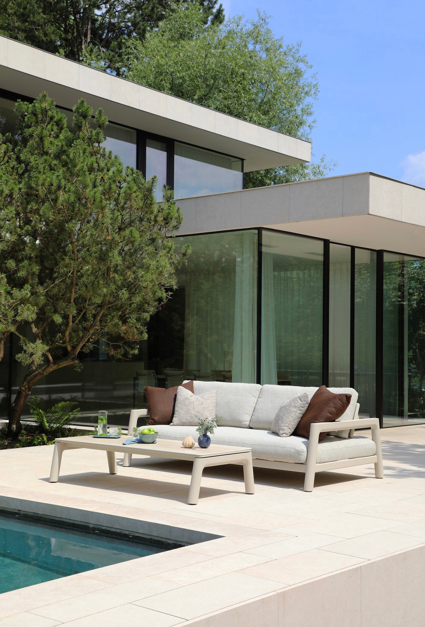 Salon de jardin modulable en aluminium inoxydable avec coussins déhoussables et déperlants beige, table basse en céramique.