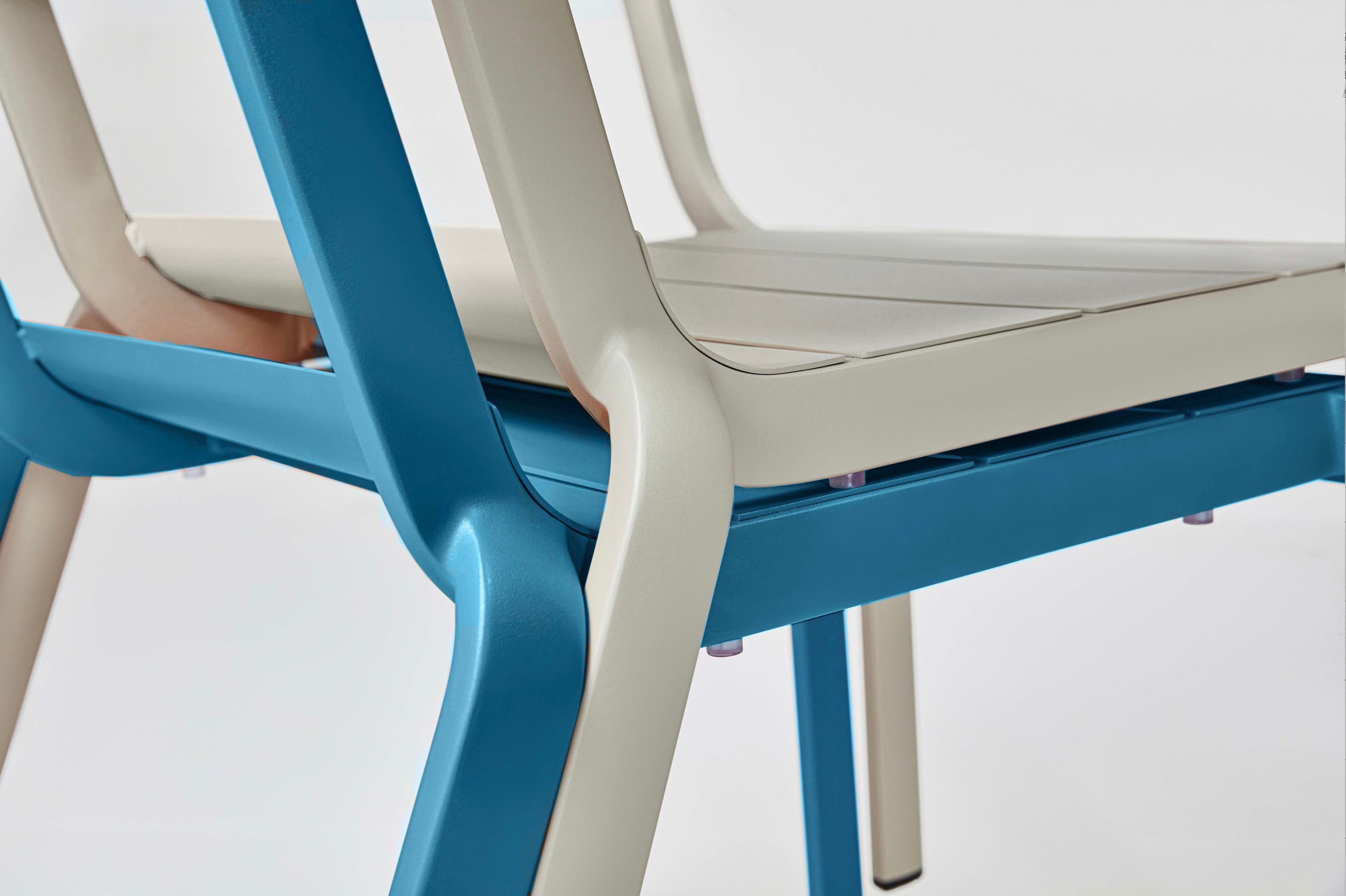 Détail d'assises empilables en aluminium haut de gamme peinturesépoxy, design innovant aux finitions beige et bleu élégantes.