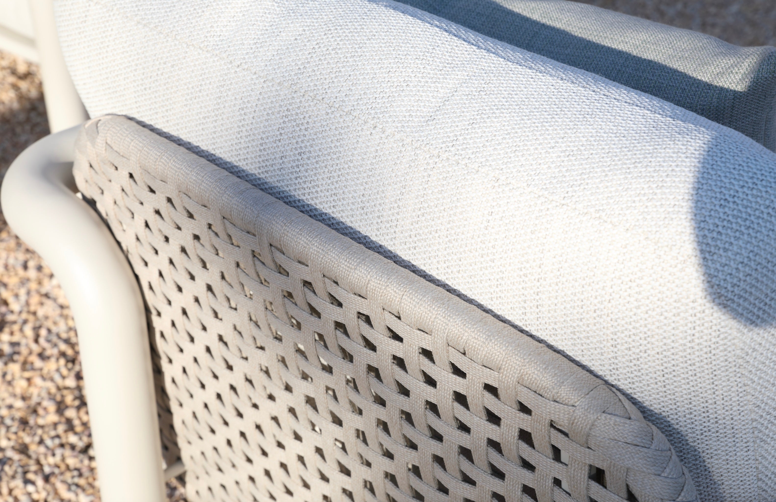 Détail de dossier d'ensemble de jardin avec structure cylindrique en aluminium, corde tressée beige et coussin en tissu.