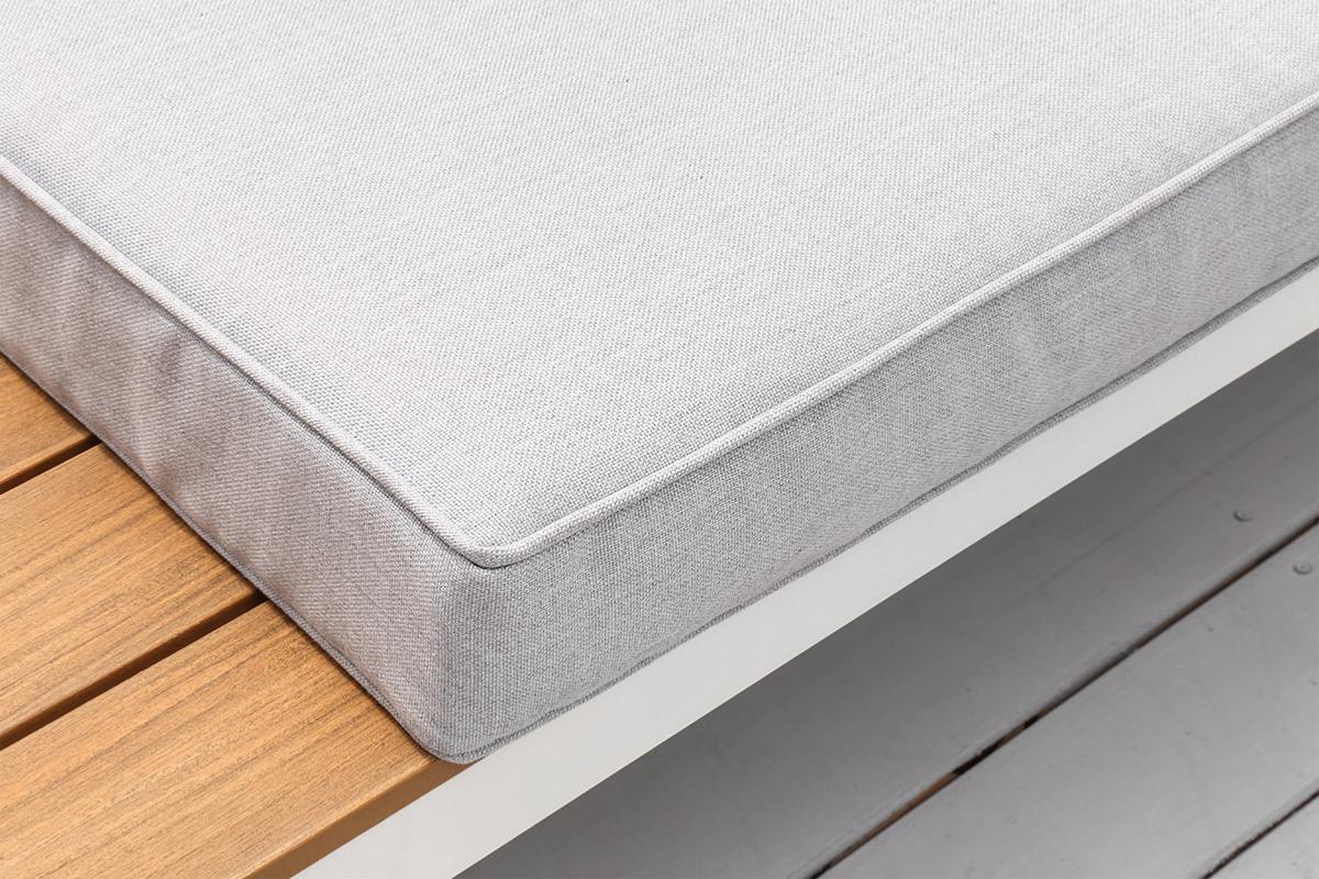 Coussin gris clair en composite imitation bois posé sur structure en aluminium haut de gamme avec peinture époxy blanche. 