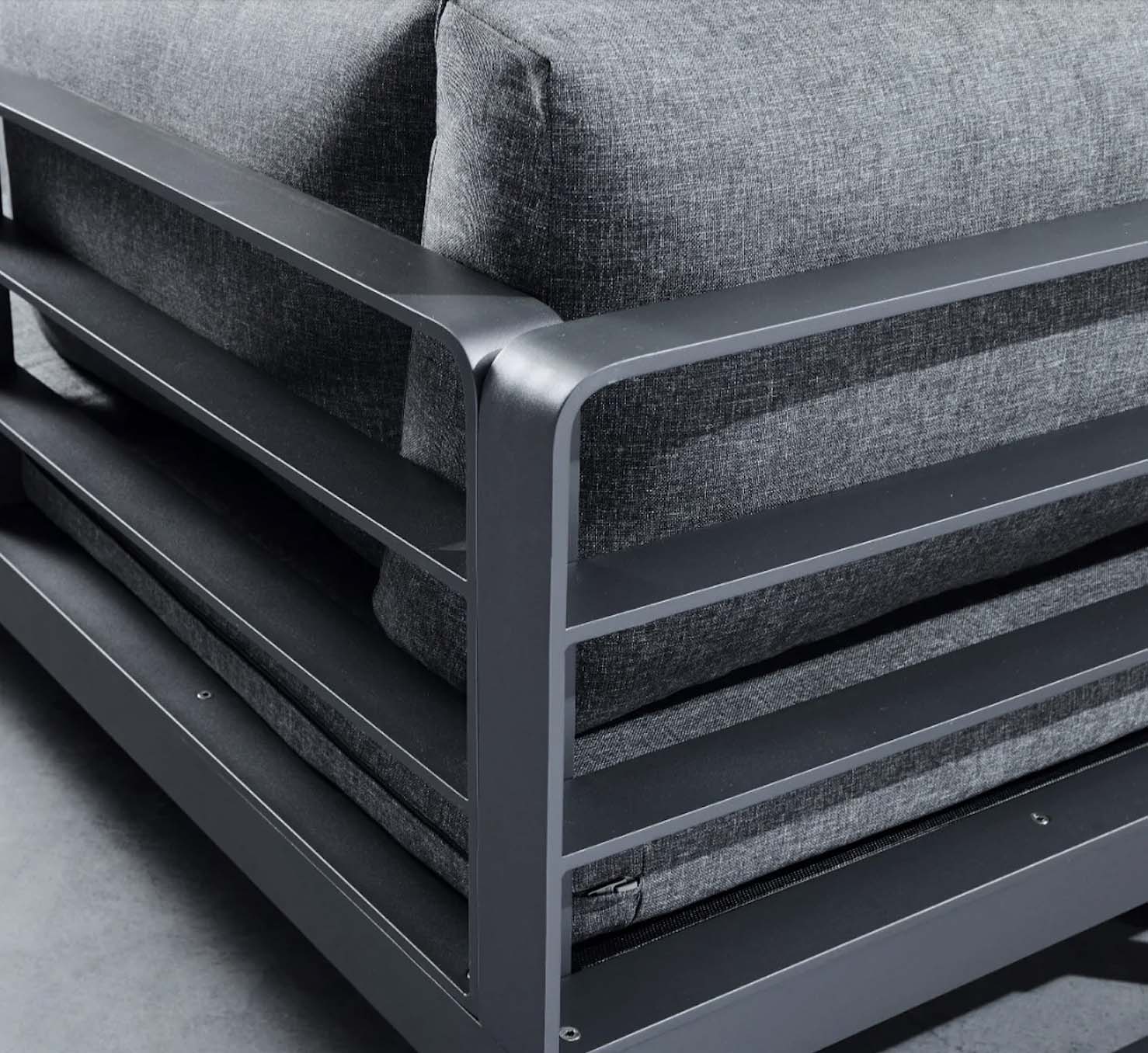 Détail d'angle du salon de jardin en aluminium haut de gamme avec peinture epoxy noire matte, coussins gris élégants.