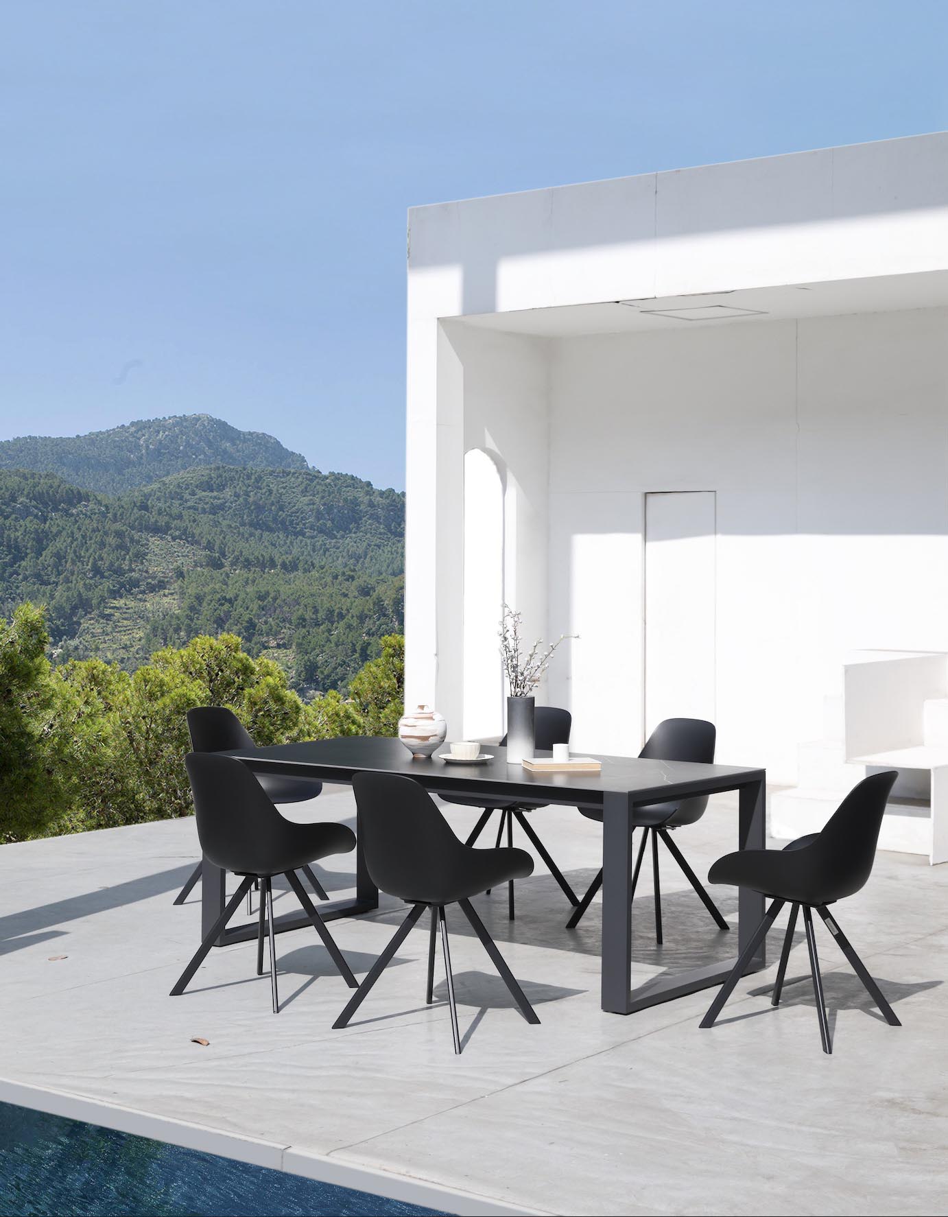 Table de jardin rectangulaire en aluminium haut de gamme noir, plateau en céramique noir élégant, six fauteuils avec housses.