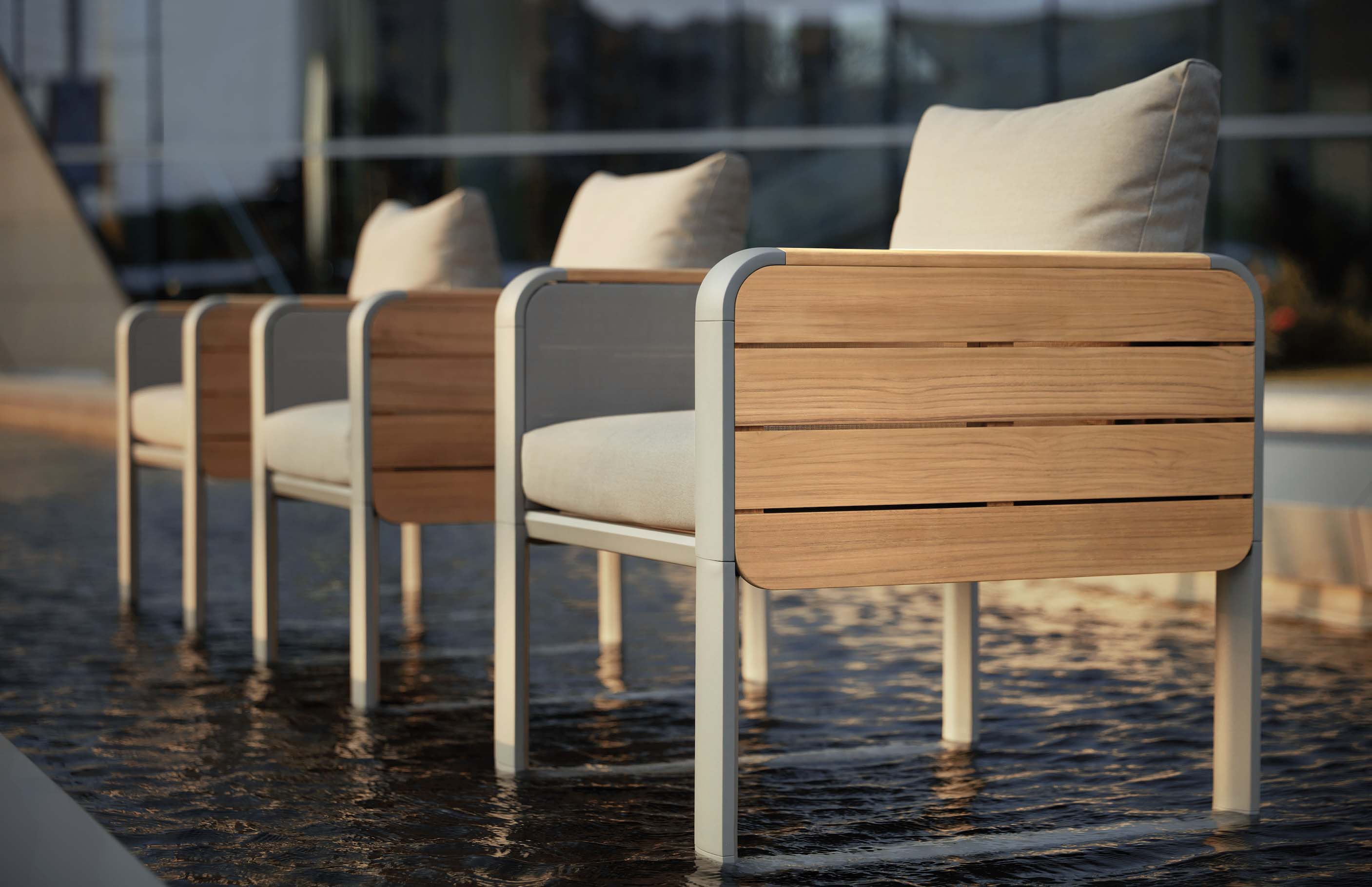 Chaises d’ensemble repas extérieur TALIA en aluminium courbé et teck FSC haut de gamme avec coussins beige sur terrasse luxe.