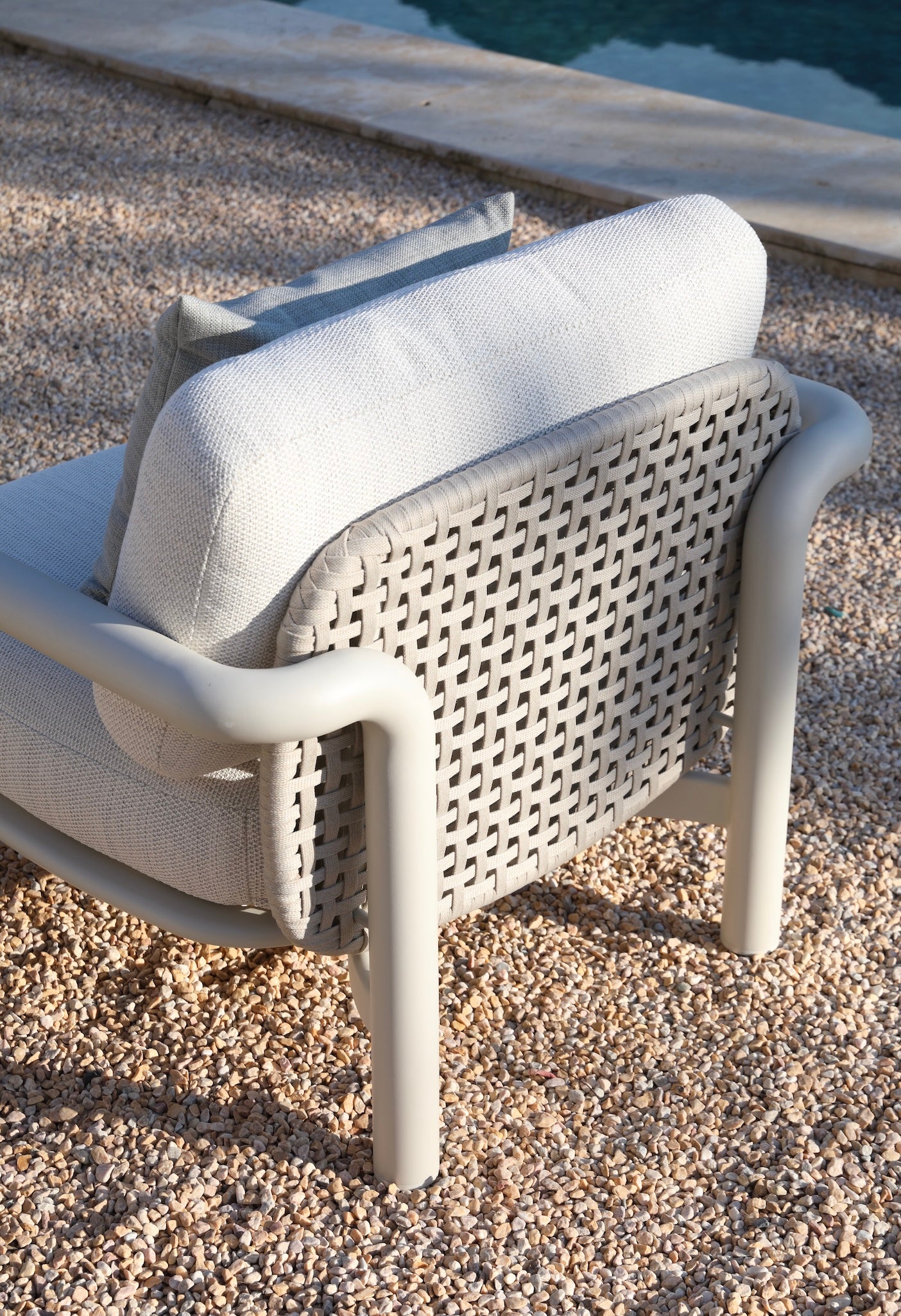 Fauteuil d'extérieur luxe en aluminium avec structure cylindrique, dossier en corde tressée blanche, coussin épais en tissu.