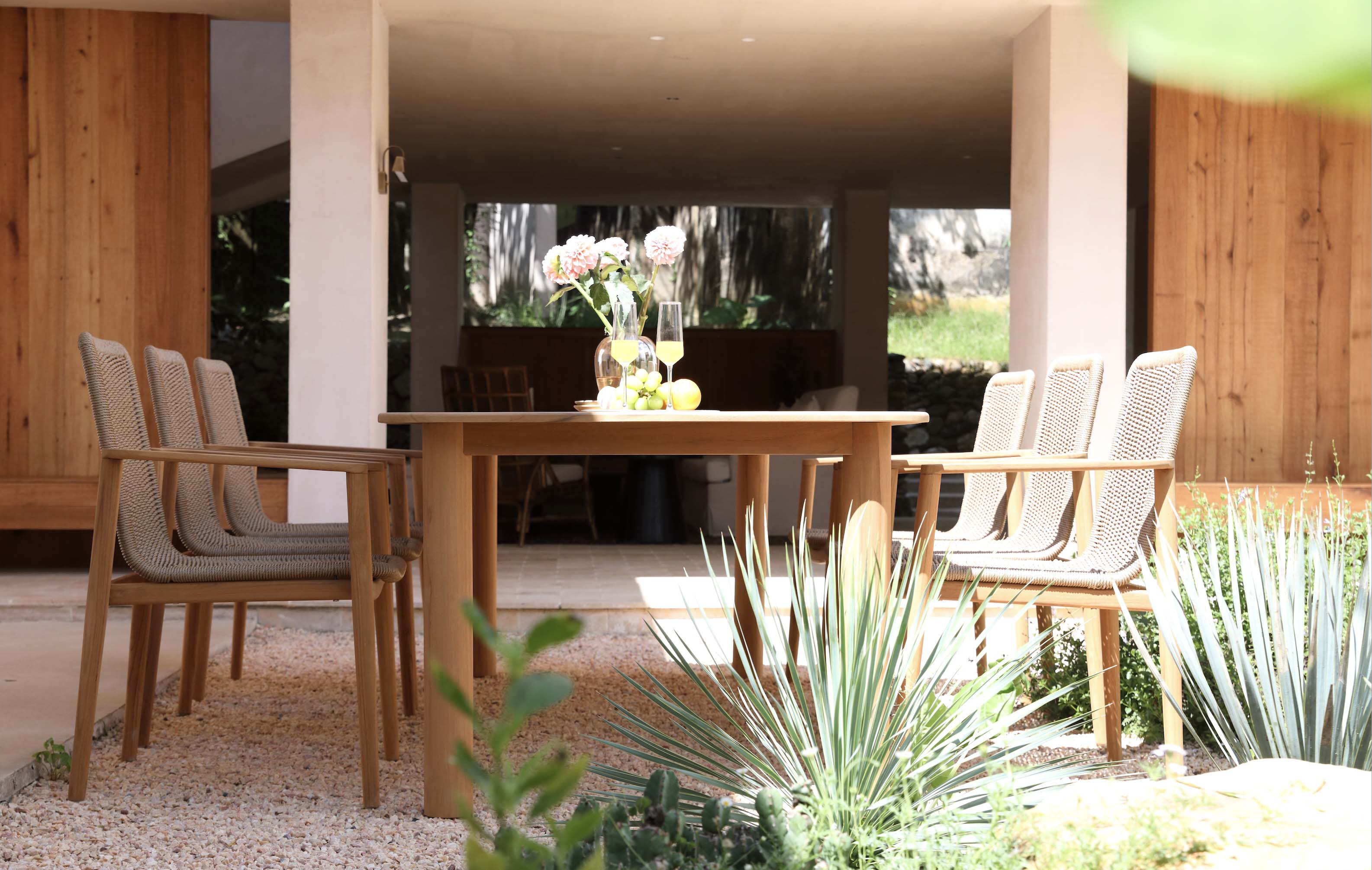 Ensemble de repas avec table en teck massif FSC chaleureux et fauteuils à corde tressée, structure en aluminium haut de gamme. 
