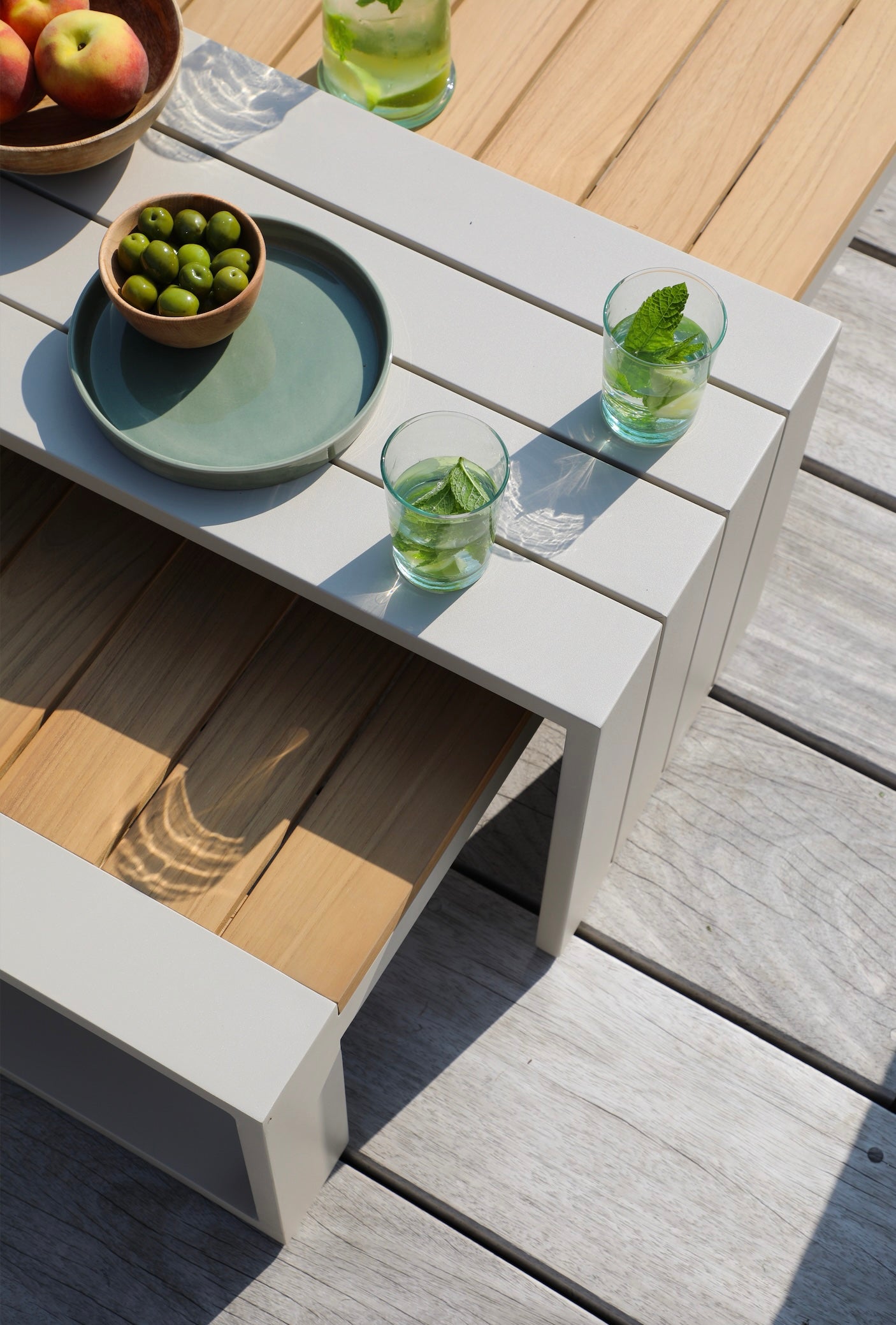 Salon de jardin modulable en aluminium inoxydable et teck FSC, design épuré avec surfaces blanches et naturelles, élégance.