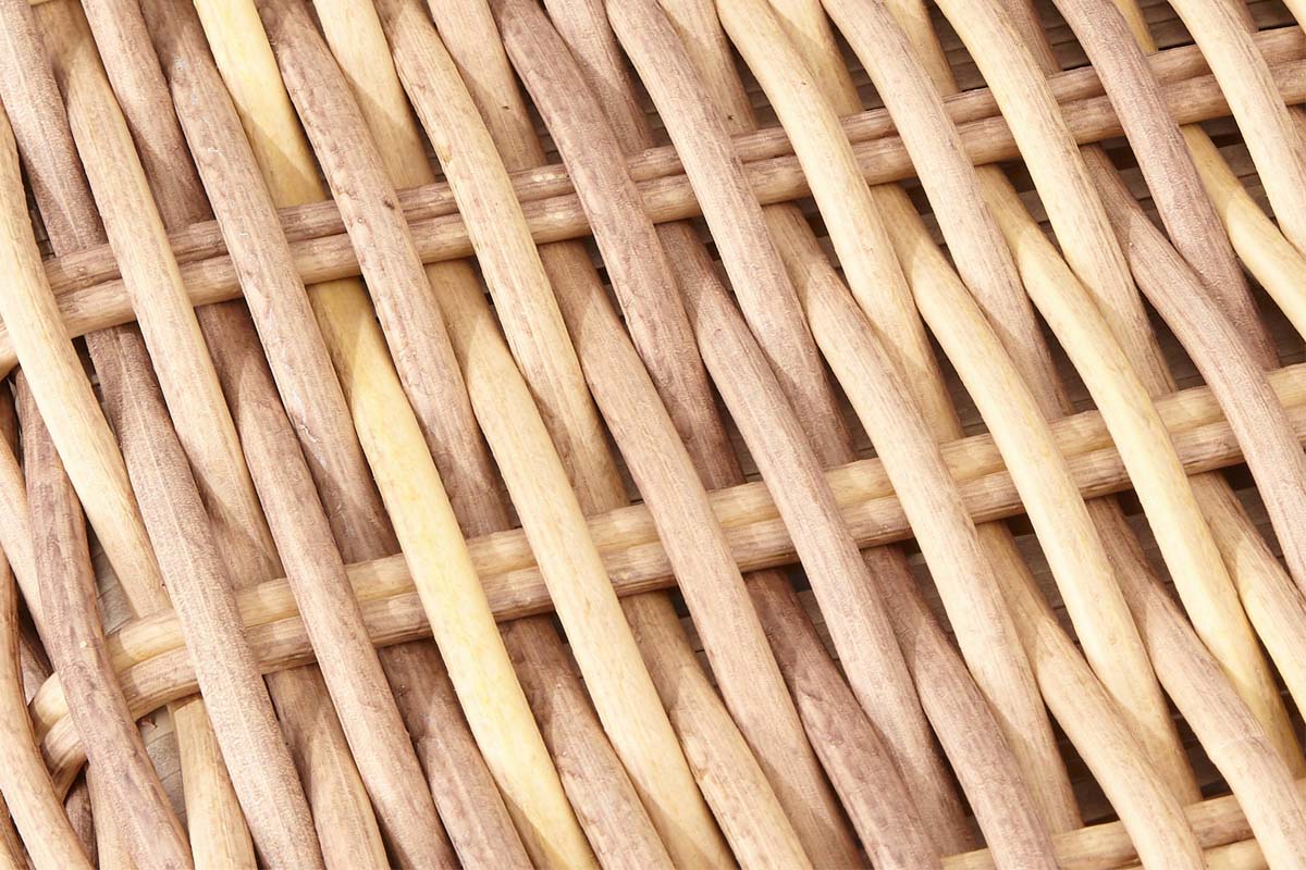 Gros plan sur le tissage en résine tressée ronde couleur naturel, aspect cosy et rustique, rappelant le charme de l'ancien.