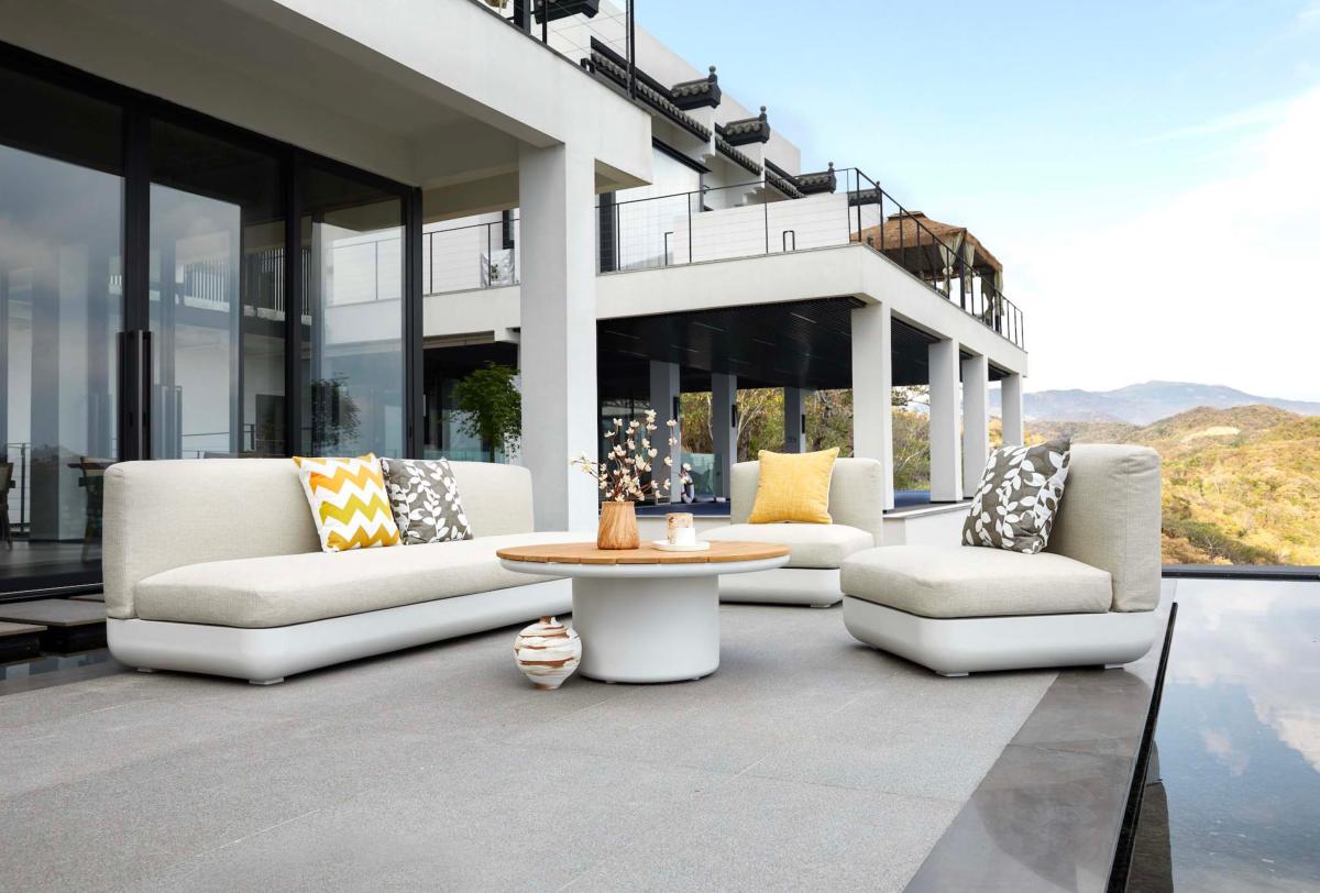 Table basse ronde design luxe en aluminium haut de gamme et teck, finition élégante, posée sur terrasse moderne, ambiance.