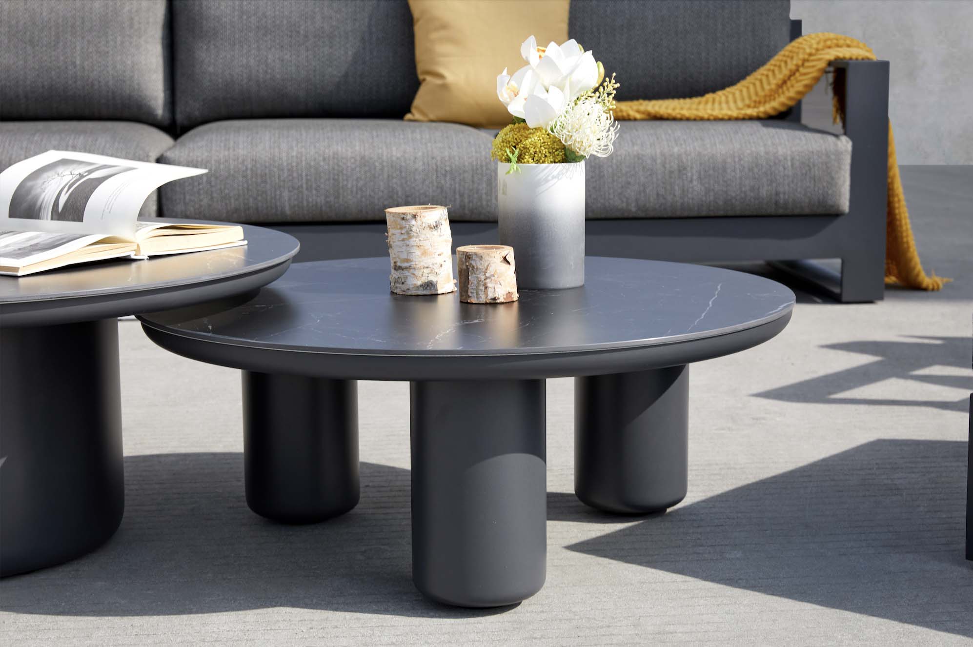 Table basse ronde noire en aluminium haut de gamme avec plateau céramique, design moderne et élégant, collection modulable. 