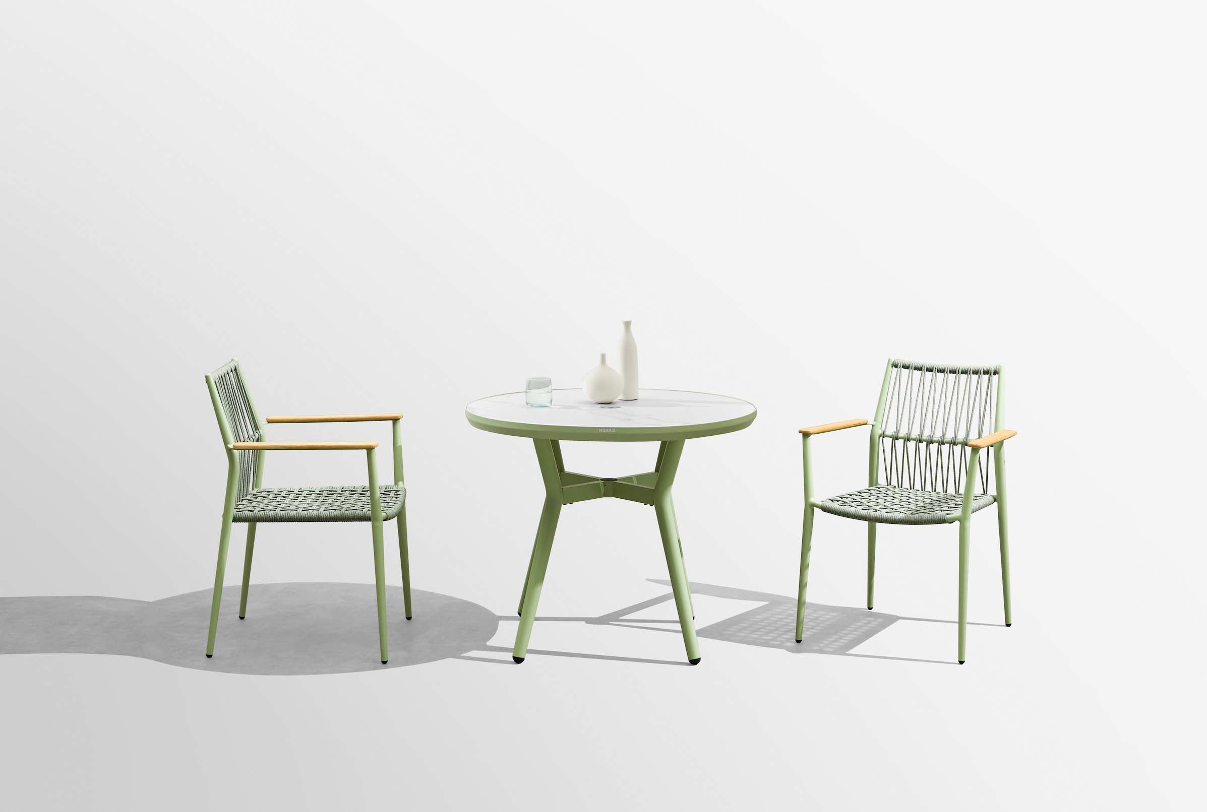 Table ronde de restaurant en aluminium vert doux, design bistrot haut de gamme, plateau céramique imitation marbre blanc. 