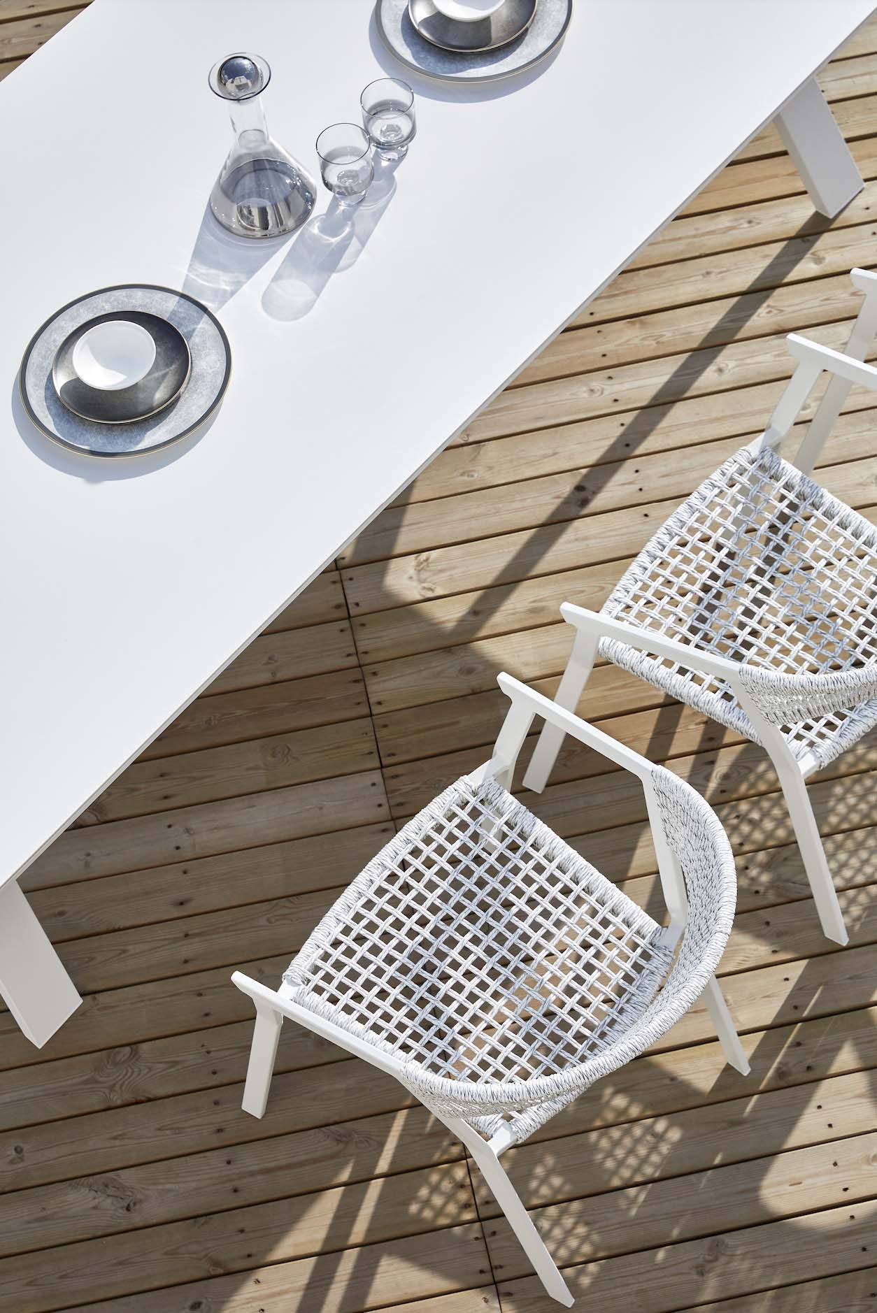 Table de jardin en aluminium haut de gamme avec plateau céramique blanc brillant, structure à peinture époxy, chaises.