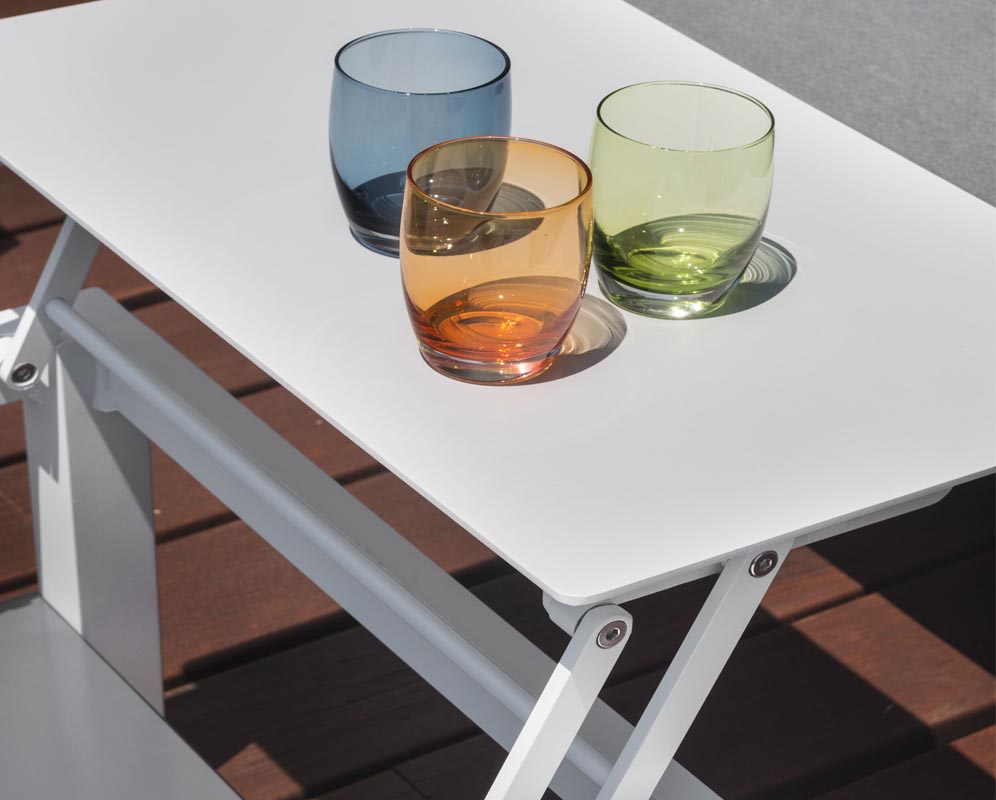Table modulable en aluminium blanc haut de gamme avec design épuré, surface lisse et pieds robustes, ambiance jardin.