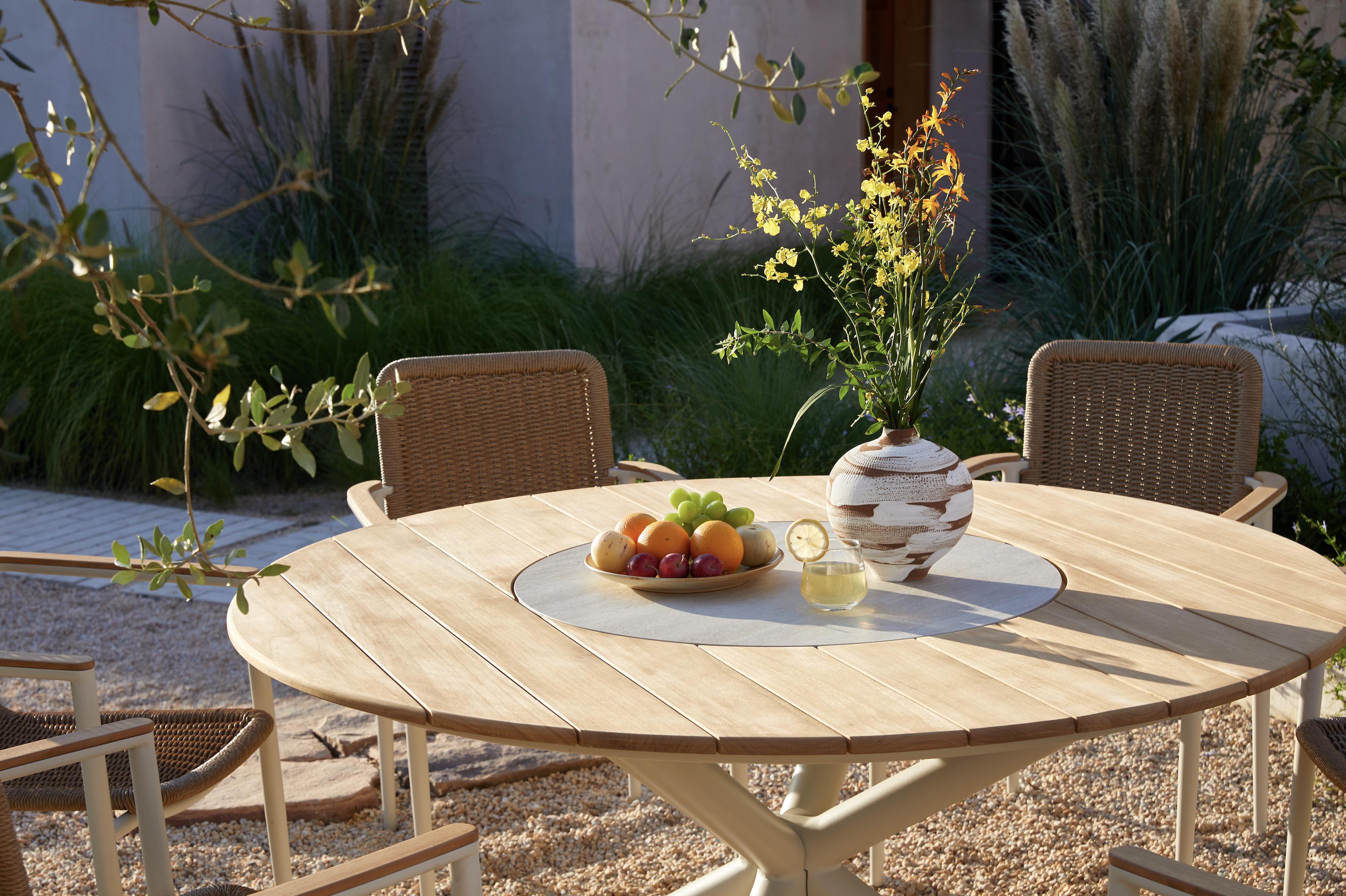 Zoom sur le plateau de la table ARIEL présentant du teck et de la céramique au centre. Le pied est en aluminium 